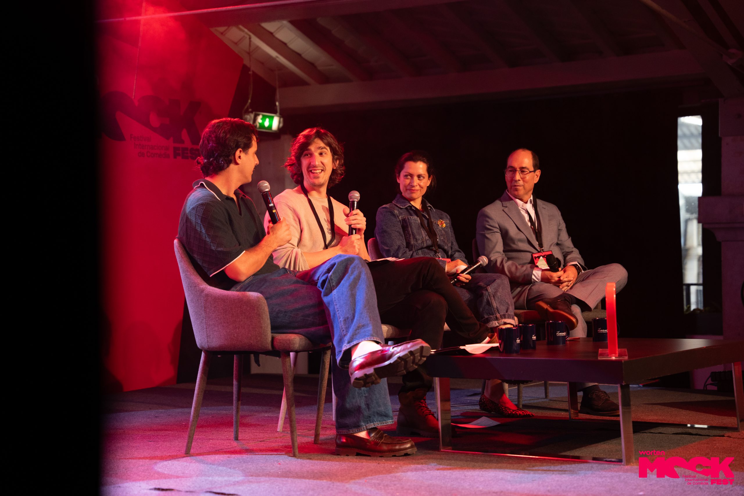 Painel de comediantes e convidados sentados no palco durante uma conversa no Worten Mock Fest