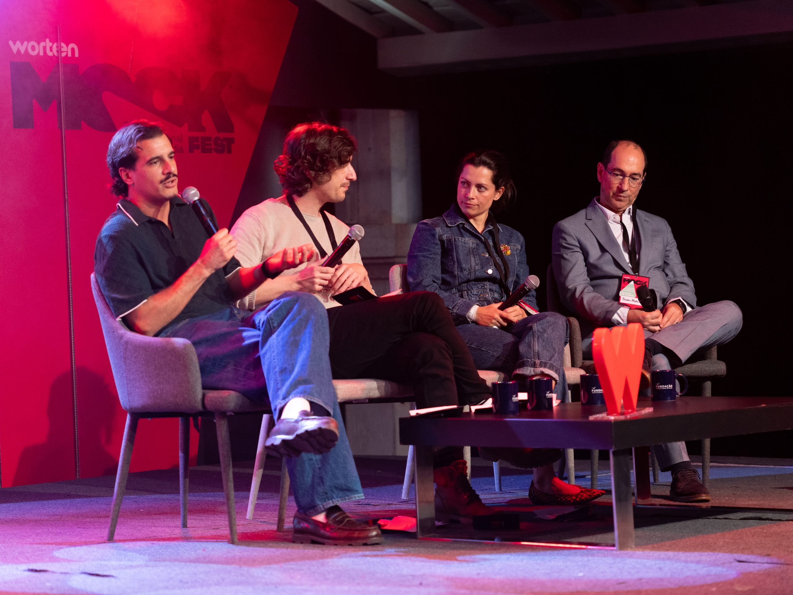 Painel de quatro oradores sentados no palco do Worten Mock Fest.