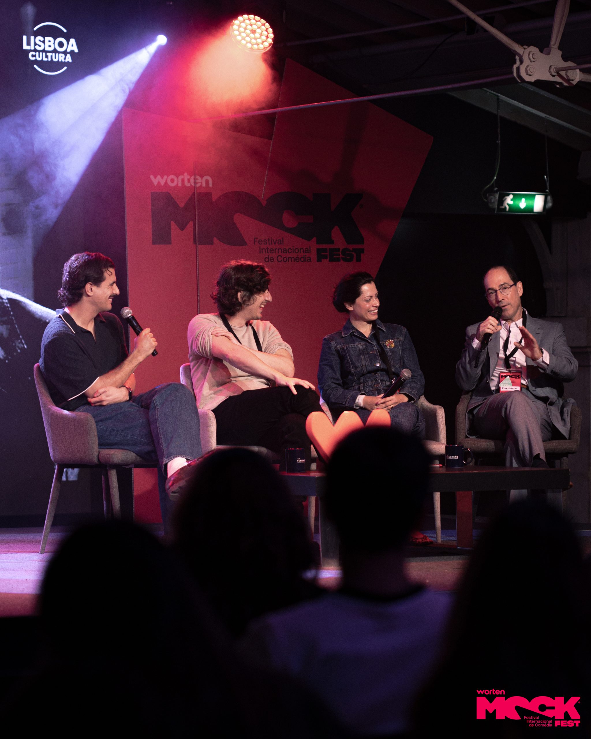 Painel de quatro oradores sentados no palco do Worten Mock Fest, todos com microfones